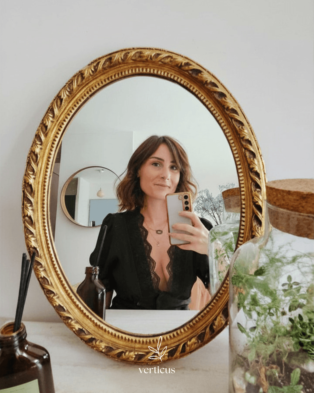Portrait de Julie dans un miroir ancien avec terrarium et détails botaniques